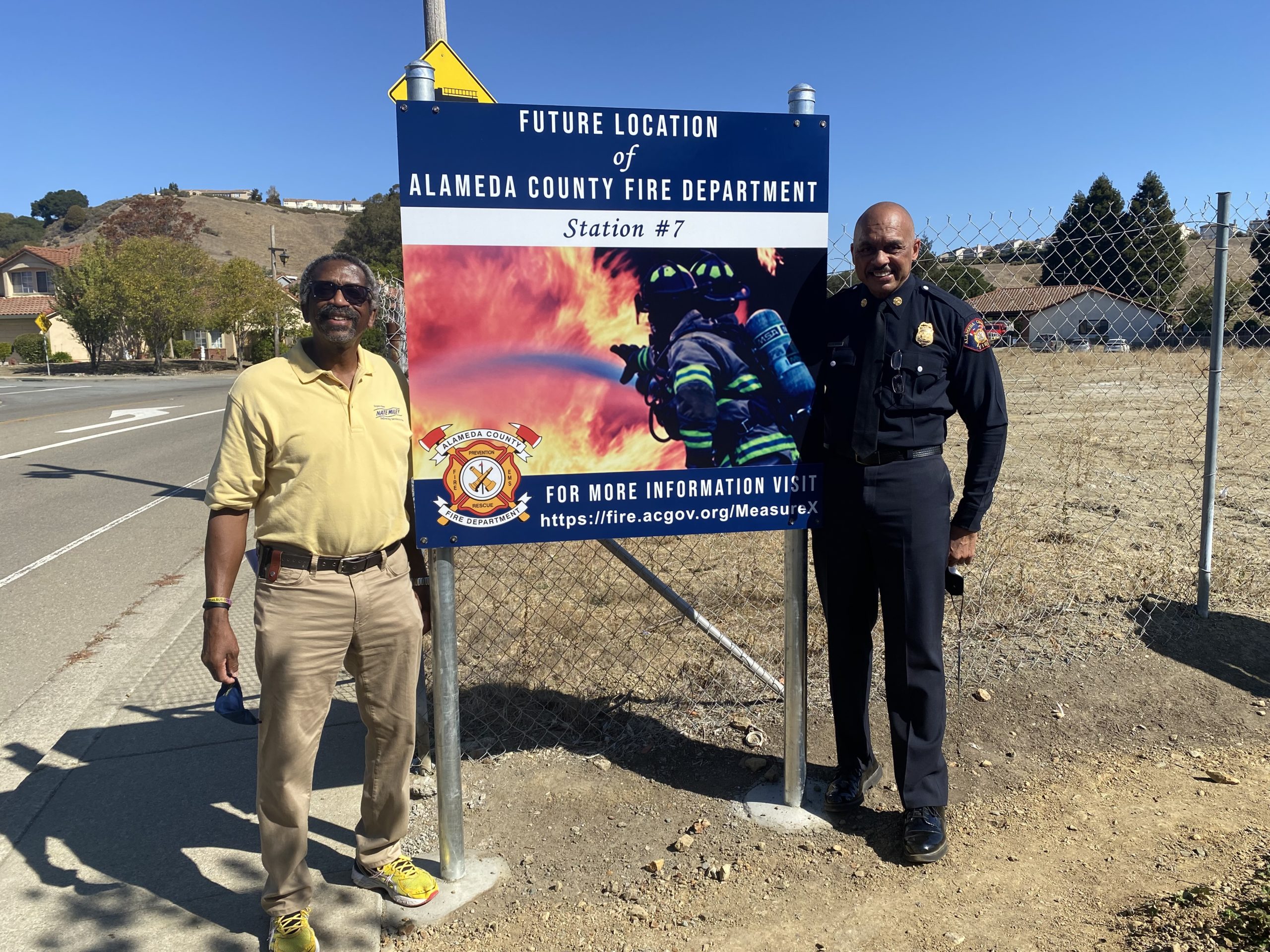 Supervisor Miley and Alameda County Fire Department Fire Chief McDonald in front of the poster for the new station 7 location